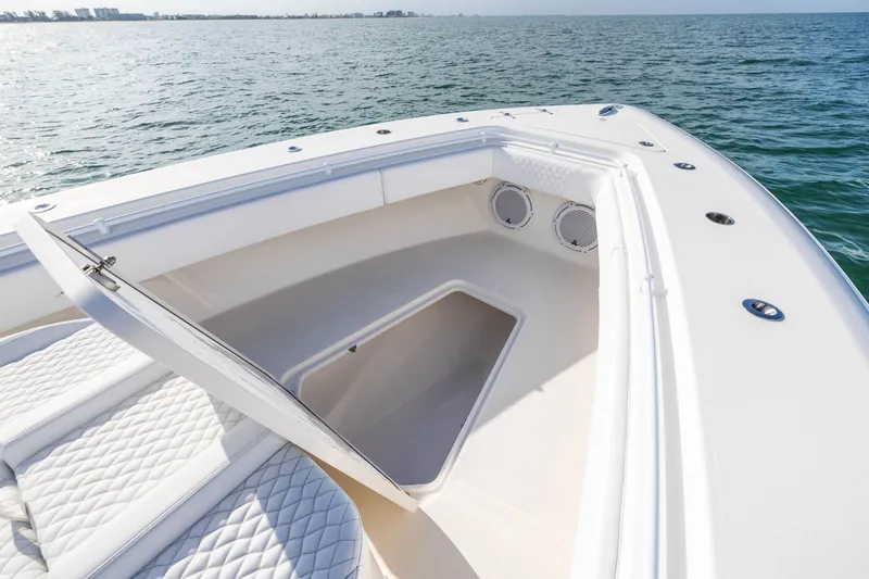 Slide: The Image of 2020 Contender 44 Fisharound boat with open storage compartment on calm ocean waters. - 16