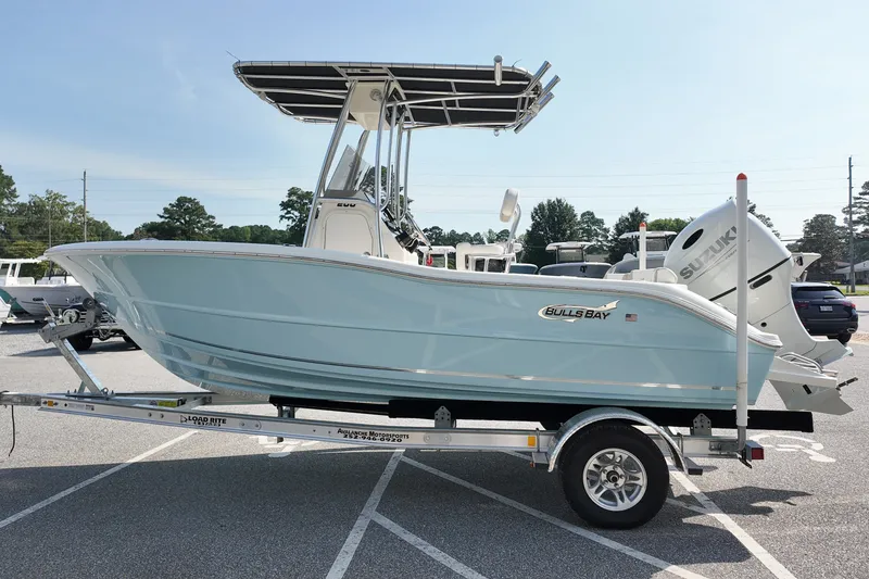 Slide: The Image of 2027 Bulls Bay 200 Center Console boat on trailer, featuring sleek design and Suzuki outboard motor. - 3