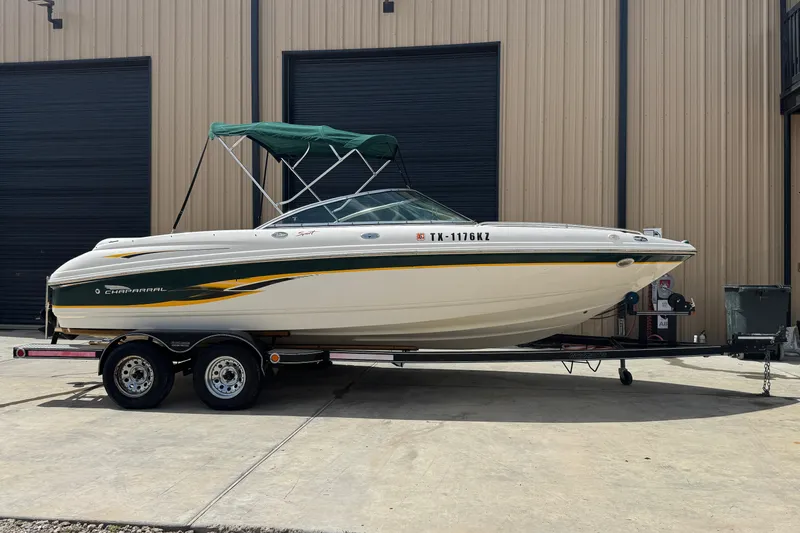 The Image of 2000 Chaparral 216 SSi boat on trailer, parked outside a warehouse. - 0