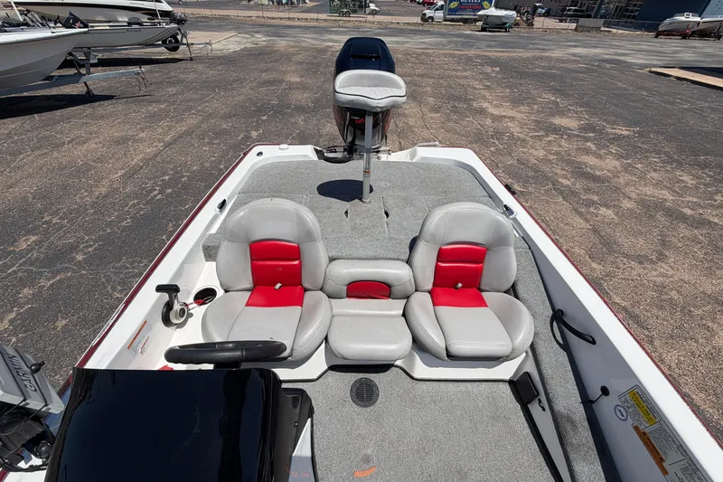 Slide: The Image of 2008 Skeeter SX190 boat interior with gray and red seating, parked on asphalt. - 27