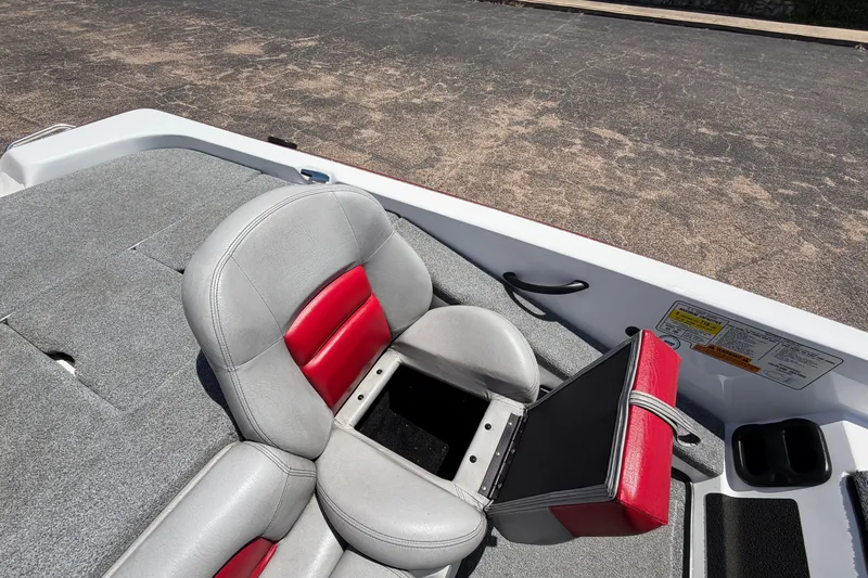 Slide: The Image of 2008 Skeeter SX190 boat seat with red and gray upholstery, open storage compartment. - 29