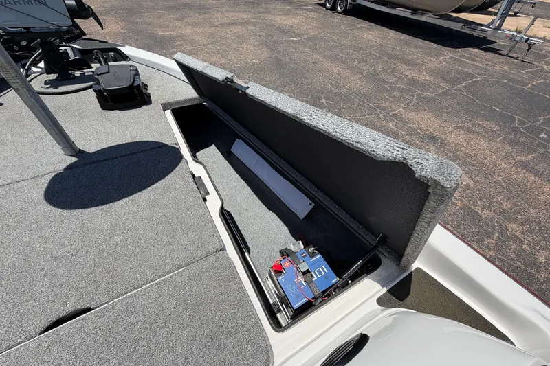Slide: The Image of 2008 Skeeter SX190 boat storage compartment with battery and equipment on deck. - 23