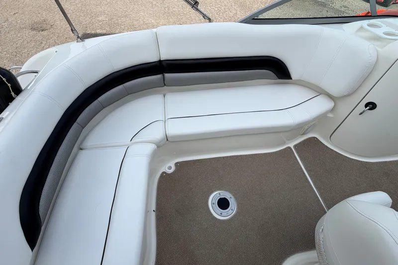 Slide: The Image of 2011 Hurricane SunDeck 237 OB boat interior with white cushioned seating and carpeted floor. - 17