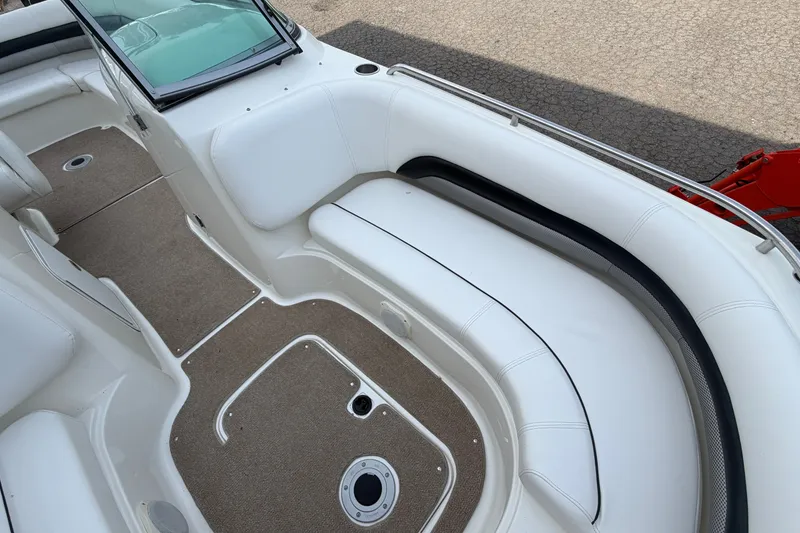 Slide: The Image of 2011 Hurricane SunDeck 237 OB boat interior with white seating and carpeted flooring. - 21
