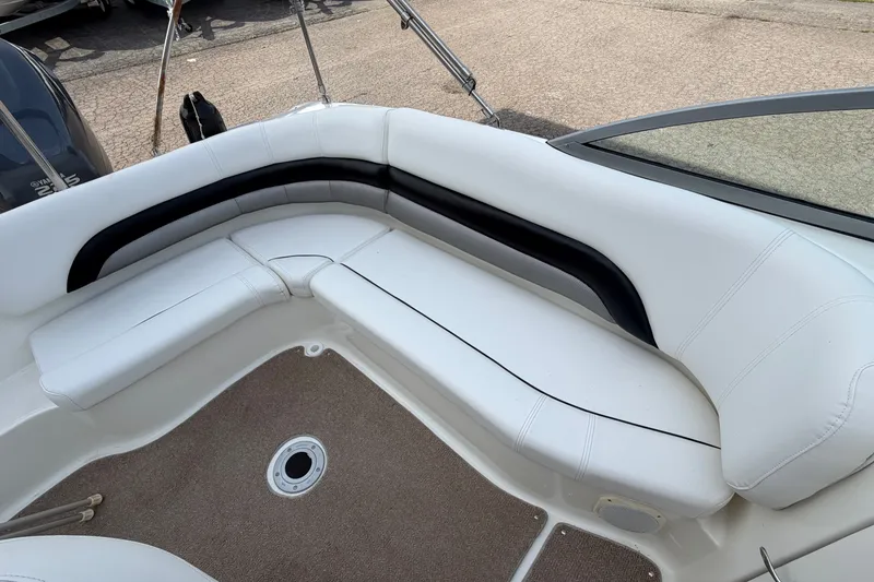 Slide: The Image of 2011 Hurricane SunDeck 237 OB boat interior with white cushioned seating and carpeted floor. - 23