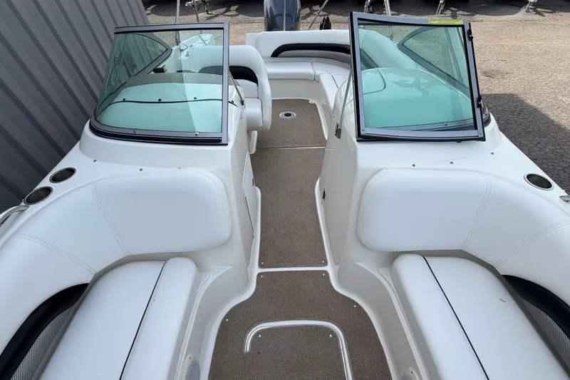 Slide: The Image of 2011 Hurricane SunDeck 237 OB boat interior with white seating and open windshield. - 20