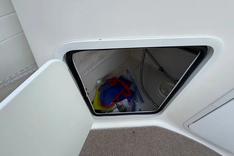 Slide: The Image of Storage compartment on a 2011 Hurricane SunDeck 237 OB boat, containing colorful items. - 11
