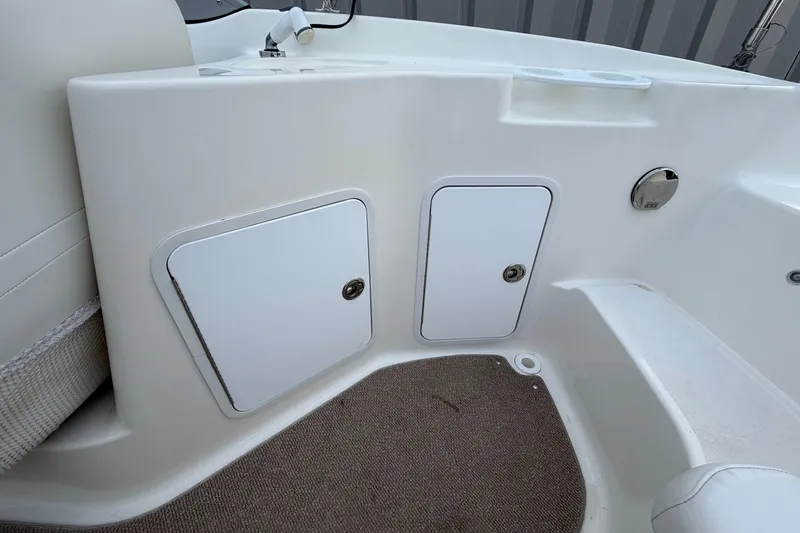 Slide: The Image of Interior view of a 2011 Hurricane SunDeck 237 OB boat, featuring storage compartments. - 14