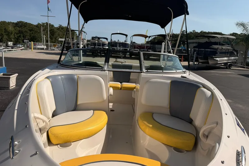 Slide: The Image of 2006 Sea Ray 185 Sport boat with yellow and white seating, docked at a marina. - 7