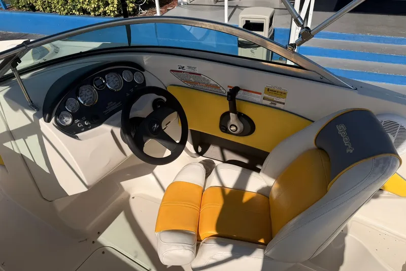 Slide: The Image of 2006 Sea Ray 185 Sport boat interior with steering wheel and yellow-accented seat. - 9