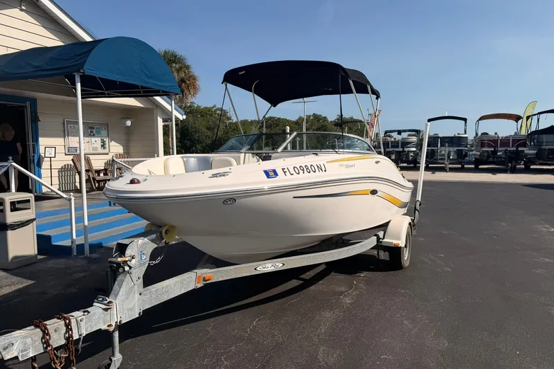 Slide: The Image of 2006 Sea Ray 185 Sport boat on trailer, parked outside a building under a clear sky. - 1
