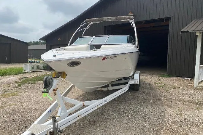 Slide: The Image of 2007 Cobalt 240 boat on trailer in front of a large garage. - 1