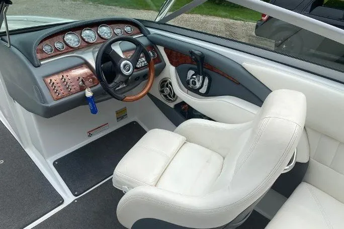 Slide: The Image of Interior of a 2007 Cobalt 240 boat with white seating and wood-accented dashboard. - 8