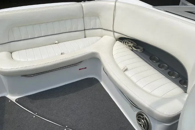 Slide: The Image of 2007 Cobalt 240 boat interior with white cushioned seating and cup holders. - 13