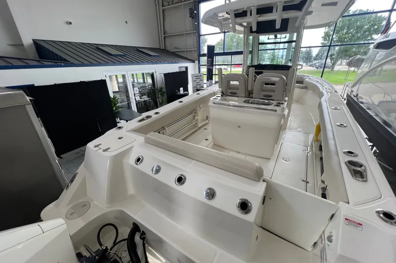 Slide: The Image of 2019 Boston Whaler 280 Outrage boat interior, showcasing seating and helm in a showroom. - 5
