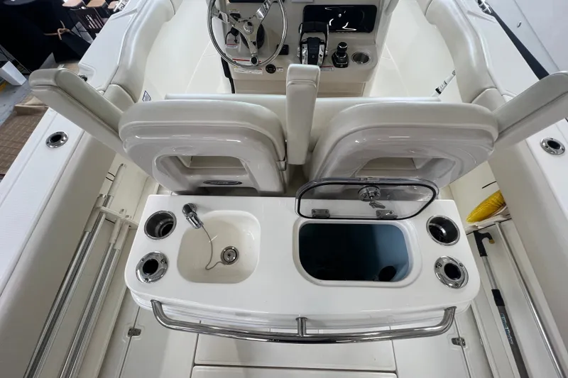 Slide: The Image of 2019 Boston Whaler 280 Outrage boat interior with helm, sink, and storage compartments. - 7