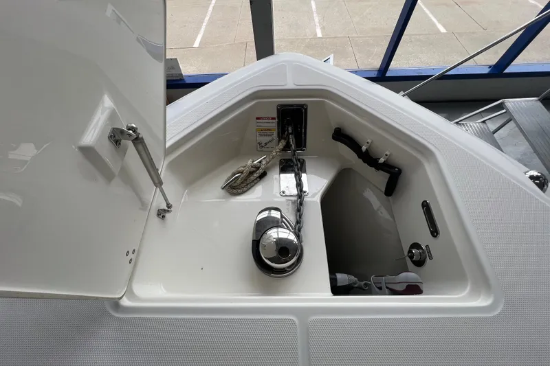 Slide: The Image of The anchor locker of the 2019 Boston Whaler 280 Outrage is open, showing ropes and anchor. - 21