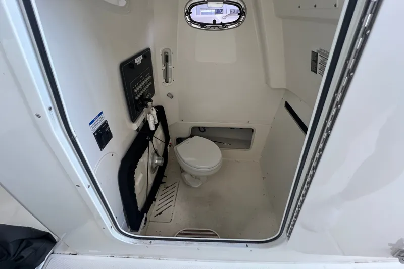 Slide: The Image of Interior of 2019 Boston Whaler 280 Outrage boat, featuring a compact marine toilet. - 22