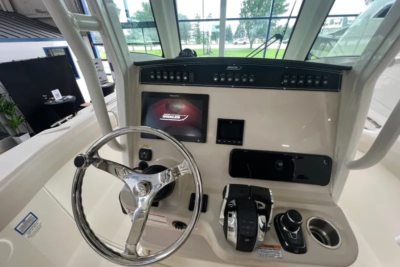 Slide: The Image of Control panel of a 2019 Boston Whaler 280 Outrage boat with steering wheel and electronics. - 12