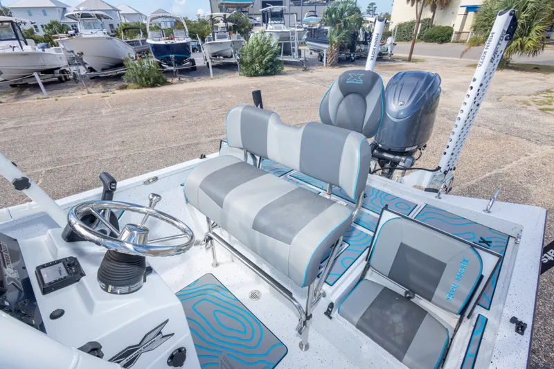 Slide: The Image of 2024 Xpress H22 Bay boat interior with seating and steering wheel, parked outdoors. - 40
