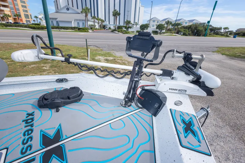 Slide: The Image of 2024 Xpress H22 Bay boat with Minn Kota Terrova trolling motor, docked near modern buildings. - 31