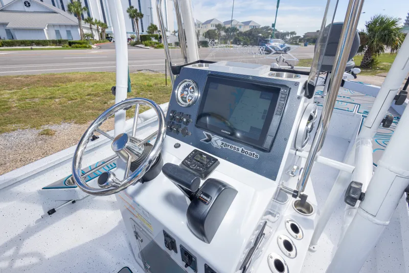 Slide: The Image of 2024 Xpress H22 Bay boat dashboard with steering wheel and navigation display. - 26