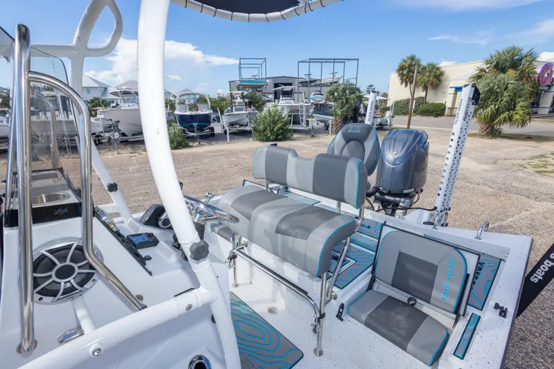 Slide: The Image of 2024 Xpress H22 Bay boat interior with seating and motor, parked outdoors. - 39