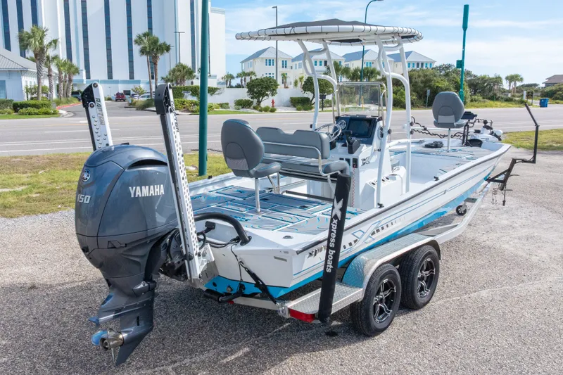 Slide: The Image of 2024 Xpress H22 Bay boat with Yamaha 150 engine, parked on a trailer. - 53