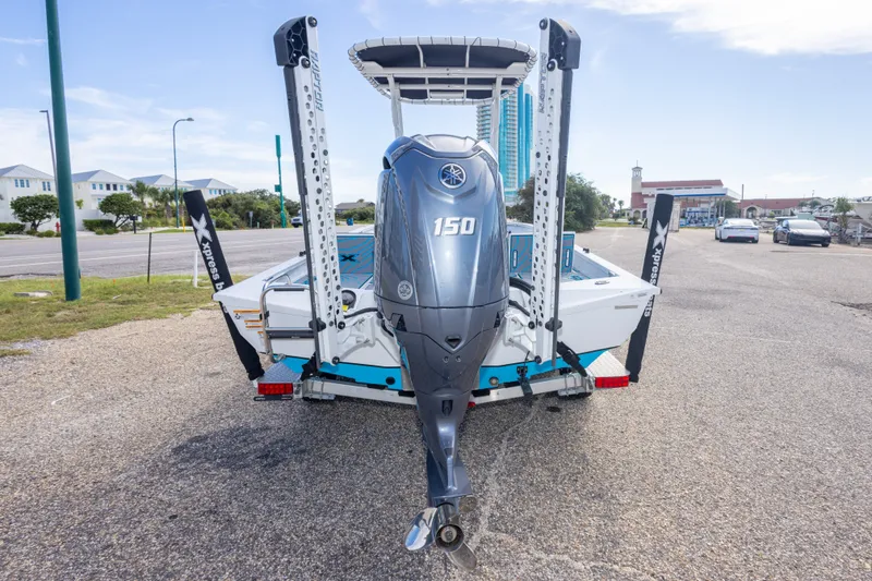 Slide: The Image of 2024 Xpress H22 Bay boat with Yamaha 150 engine, parked on a trailer. - 16