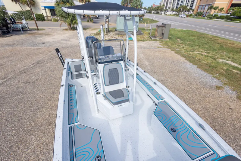 Slide: The Image of 2024 Xpress H22 Bay boat with sleek design and modern seating, parked near a road. - 33