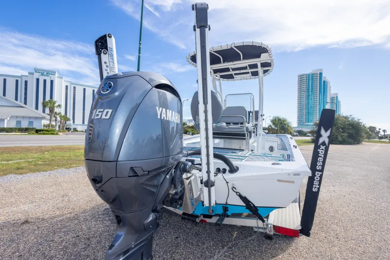 Slide: The Image of 2024 Xpress H22 Bay boat with Yamaha 150 engine, parked near modern buildings. - 51