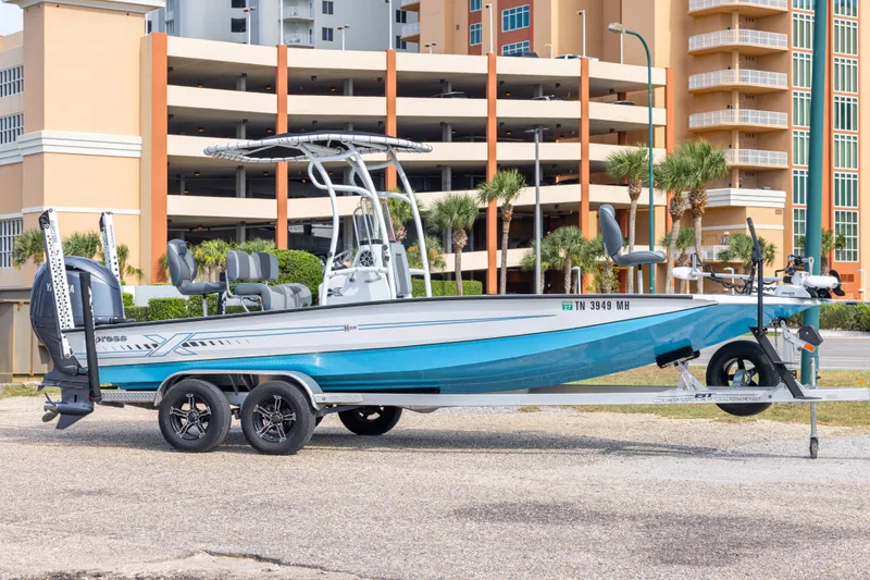 The Image of 2024 Xpress H22 Bay boat on trailer, parked near modern buildings. - 0