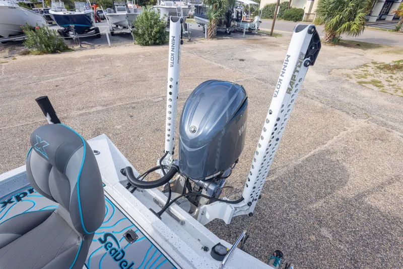 Slide: The Image of 2024 Xpress H22 Bay boat with Minn Kota motor, parked on a concrete surface. - 49