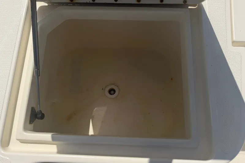 Slide: The Image of Open storage compartment on 2006 World Cat 270 TE boat, featuring a drain plug. - 43