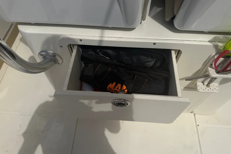 Slide: The Image of Open storage drawer on 2006 World Cat 270 TE boat with tools and bag. - 40