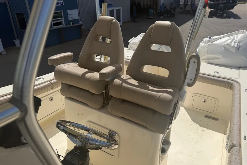 Slide: The Image of Dual captain seats on 2006 World Cat 270 TE boat, featuring beige upholstery and steering wheel. - 24
