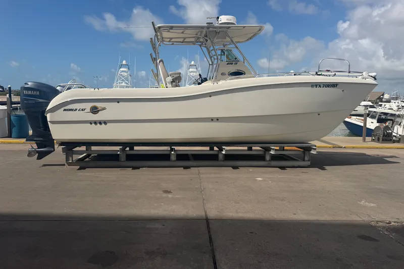 Slide: The Image of 2006 World Cat 270 TE boat on dock with Yamaha engines, under blue sky. - 2
