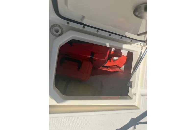 Slide: The Image of Open storage compartment on 2006 World Cat 270 TE boat with life jackets inside. - 48