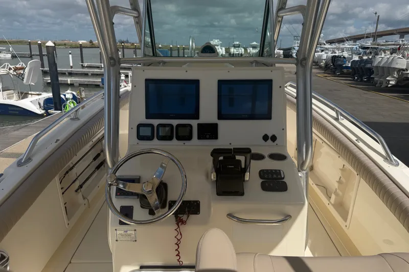 Slide: The Image of 2006 World Cat 270 TE boat dashboard with steering wheel and navigation screens at marina. - 11
