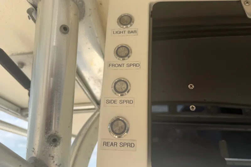 Slide: The Image of Control panel with labeled buttons for light bar and spreader lights on a 2006 World Cat 270 TE. - 38