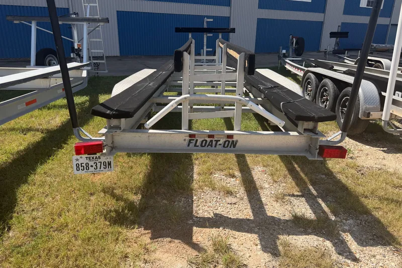 Slide: The Image of Boat trailer with Texas license plate, parked on grass near blue building. - 57