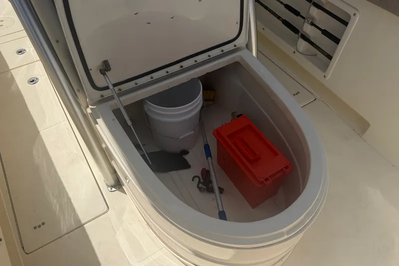 Slide: The Image of Open storage compartment on 2006 World Cat 270 TE boat with bucket and red toolbox. - 17