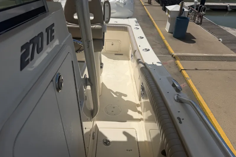 Slide: The Image of 2006 World Cat 270 TE boat interior at dock, showcasing seating and deck layout. - 19
