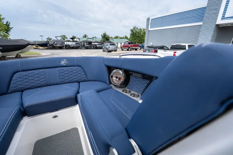 Slide: The Image of 2021 MasterCraft X24 boat interior with blue seating and cup holders. - 34