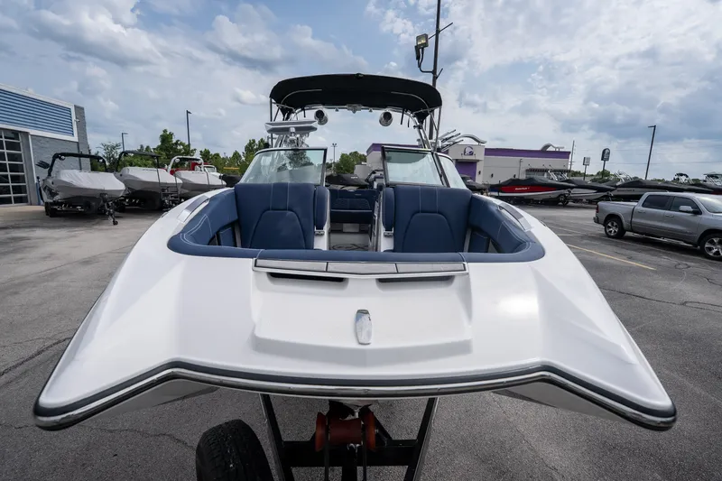 Slide: The Image of 2021 MasterCraft X24 boat with blue seating, displayed outdoors on a trailer. - 11
