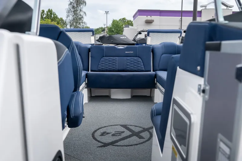 Slide: The Image of Interior view of 2021 MasterCraft X24 boat with blue seating and logo on carpet. - 38