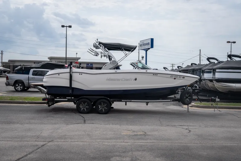 Slide: The Image of 2021 MasterCraft X24 boat on trailer in parking lot, side view. - 8