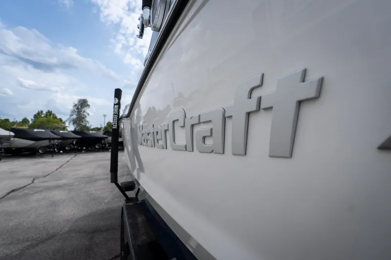 Slide: The Image of 2021 MasterCraft X24 boat side view with logo, parked outdoors. - 15