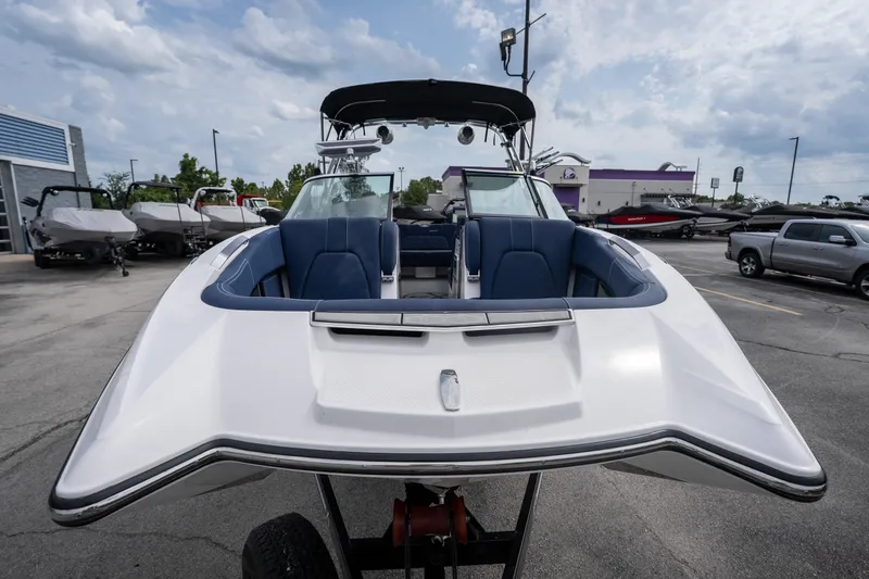 Slide: The Image of 2021 MasterCraft X24 boat with blue seating, displayed outdoors on a trailer. - 12