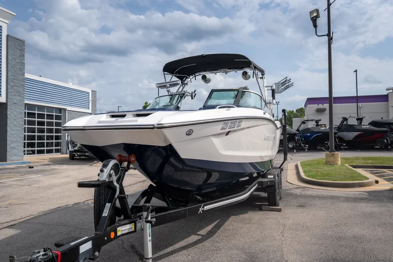 Slide: The Image of 2021 MasterCraft X24 boat on trailer in dealership parking lot. - 2
